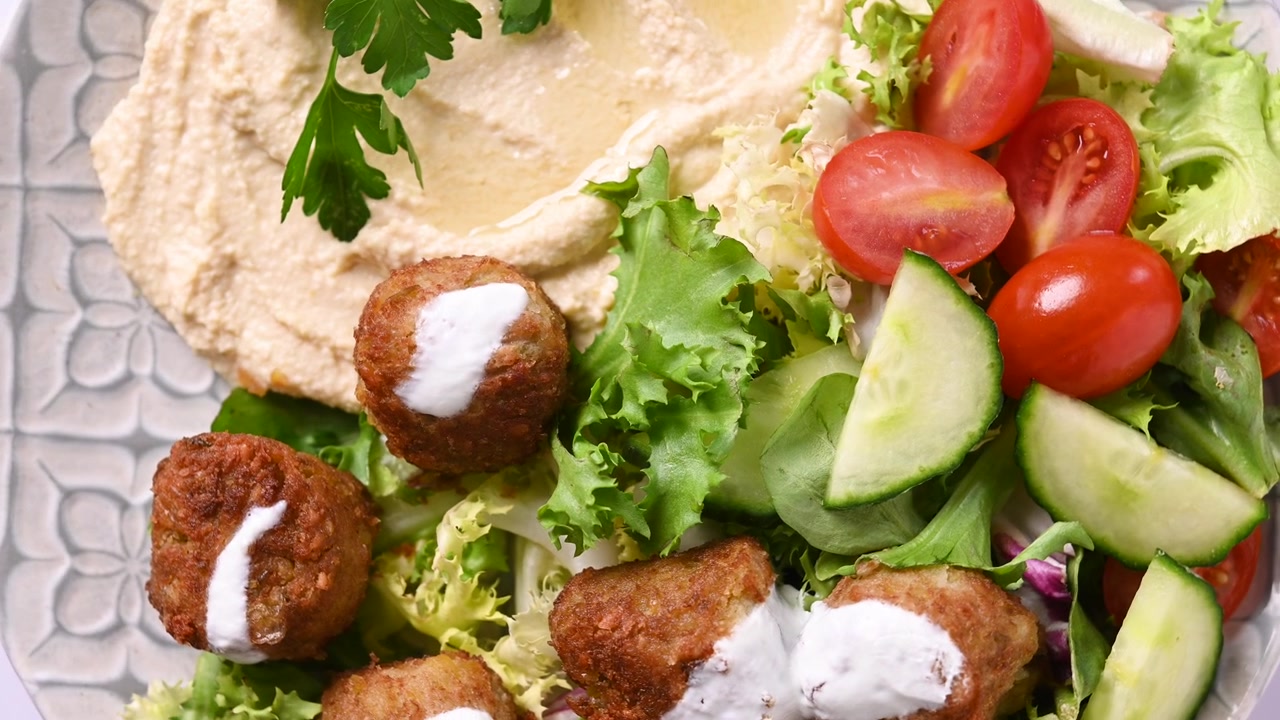 Falafel tradizionale servito con hummus e insalata fresca.