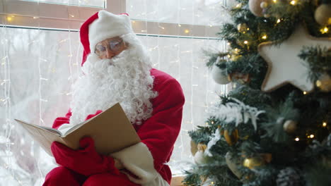 santa claus reading a book by the window