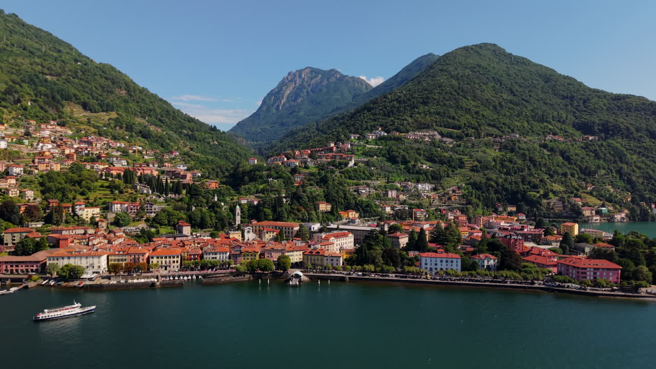 Drone Retreat Shot Over Lake Como Waterfront With Approaching Ferry