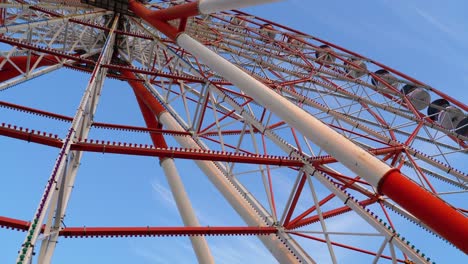 ferris wheel rotates against the sky in summer day