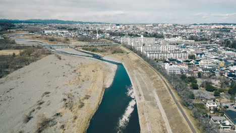 Tama-Fluss-Entlang-Der-Entwickelten-Stadt-In-Der-Nähe-Der-Fachwerkbrücke-Der-Itsukaichi-Linie-In-Tokio,-Japan