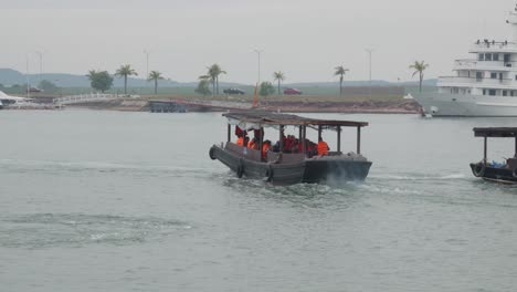 tourists riding on traditional wooden boat cruising in the ha long bay in vietnam