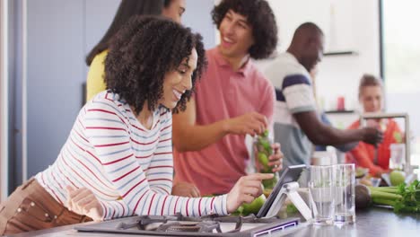 Happy-group-of-diverse-friends-preparing-healthy-drink-in-kitchen-together