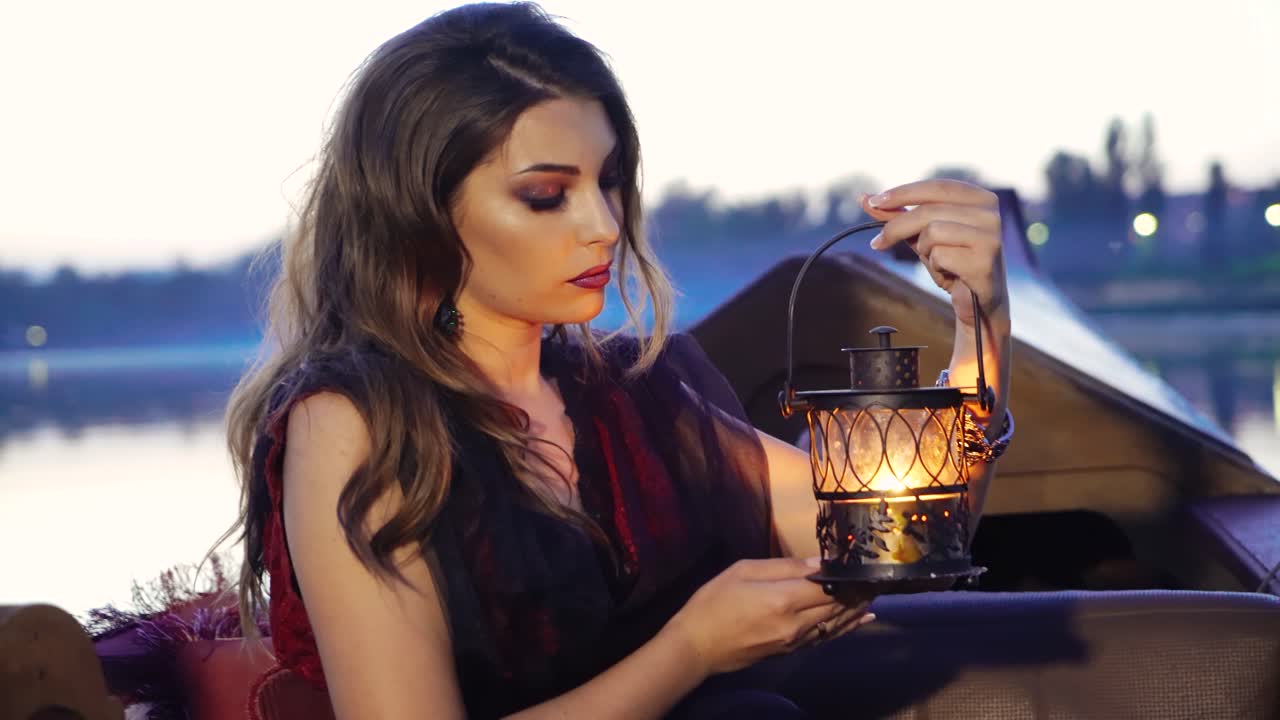 Young sexy woman on boat at sunset. Gondolas on a canal in Venice, Italy. Concept of female beauty, rest in the nature, and water travel.