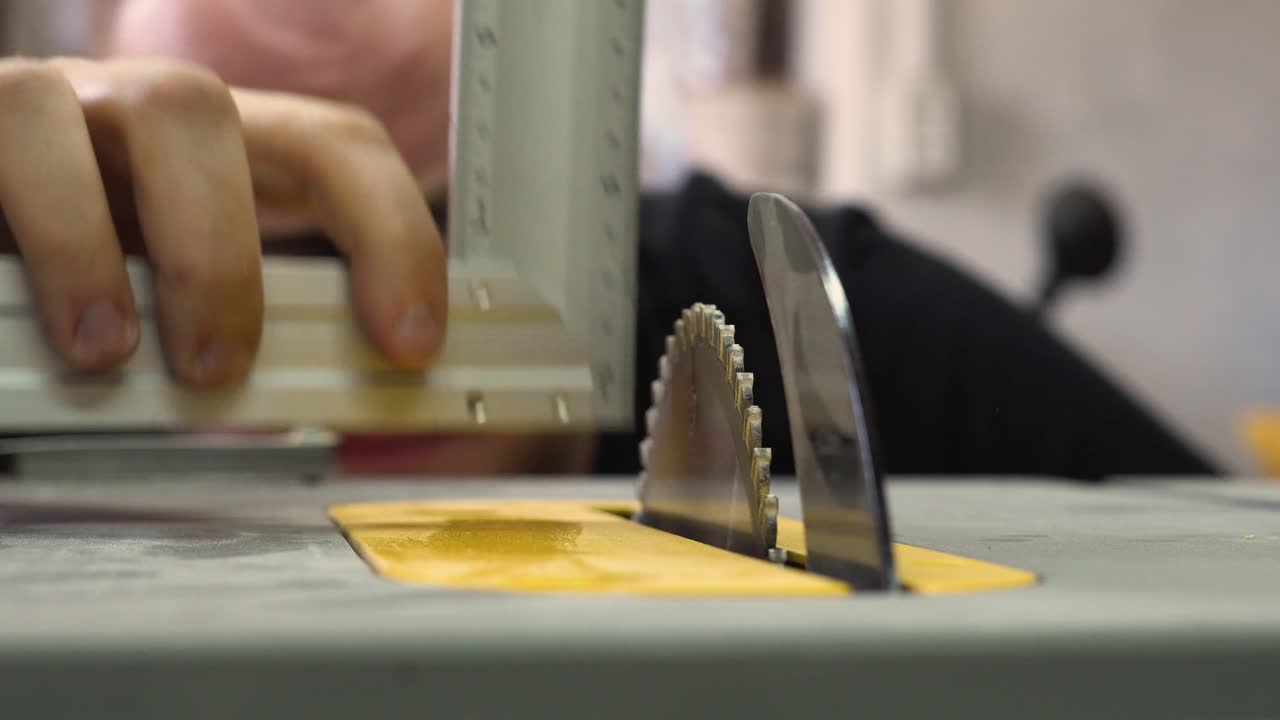 Una persona controlla l'angolo della lama della sega con un righello in un'officina