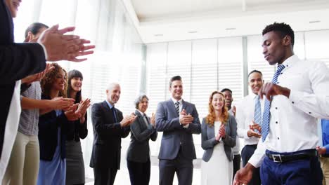 hombre de negocios bailando mientras sus colegas aplauden