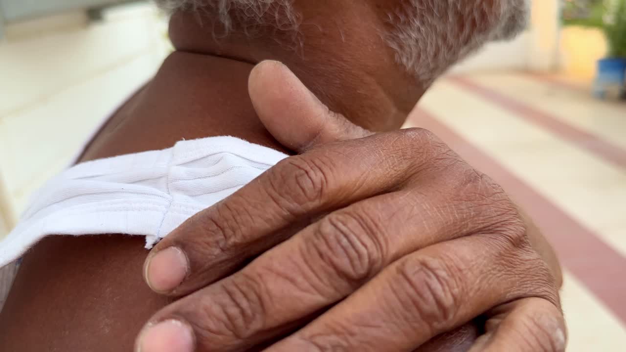 Closeup of man having shoulder pain, Closeup of Man massaging his shoulder to ease his pain