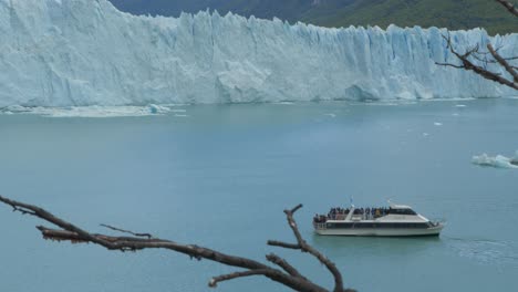 a tourist boat sails alongside a massive glacier in patagonia