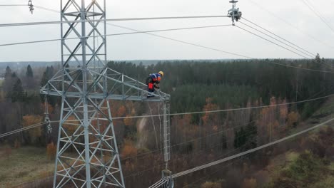 Ingenieur-Arbeitet-Hoch-Oben-Am-Pylon-Und-Hebt-Geräte-Hoch