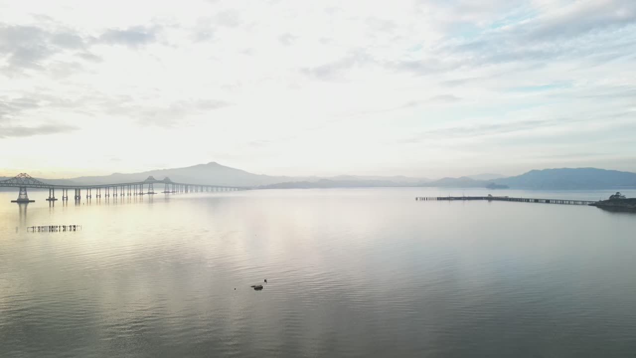Sunset white reflections of light on water, Richmond Bridge from Point Molate Beach Richmond California USA