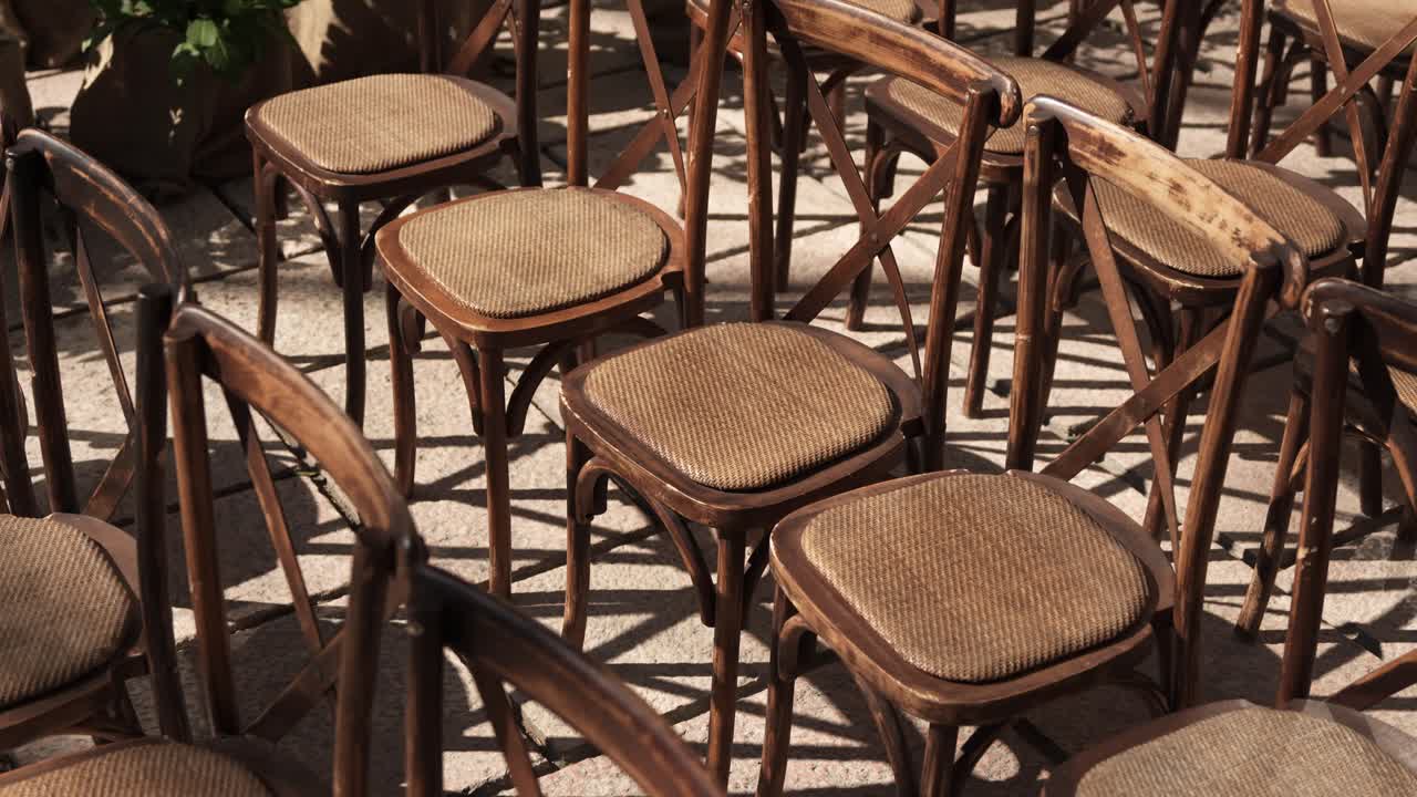 rows of rustic wooden chairs prepared for outdoor wedding event