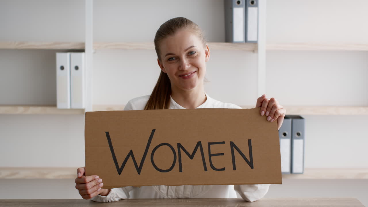 Mujer sosteniendo un cartel que dice "Mujeres"