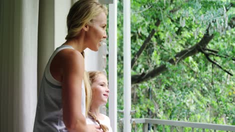 Mother-and-daughter-standing-together-in-balcony-4k
