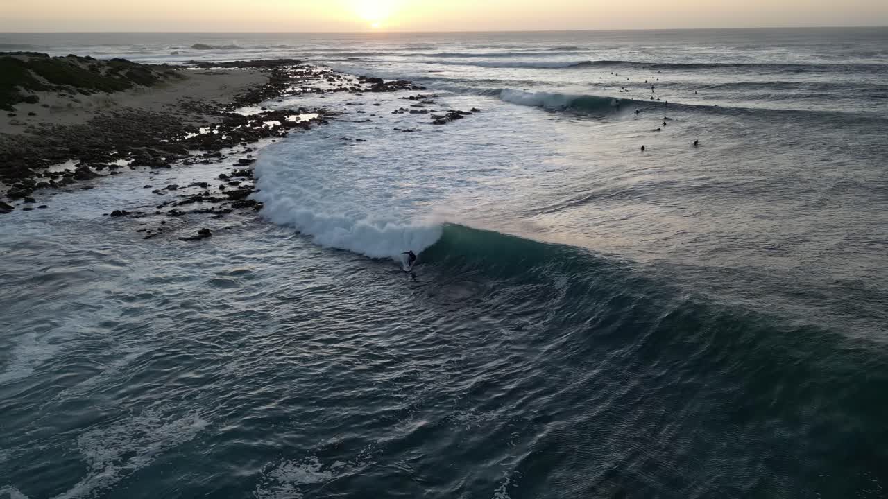 Surfista che cavalca un'onda al crepuscolo, Australia Occidentale.