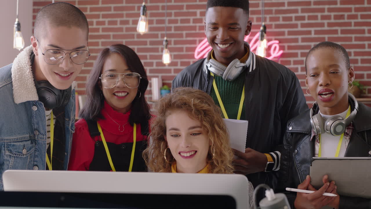 happy business people celebrating victory cheering excited enjoying watching entertainment on computer screen excited colleagues high five spontaneous celebration in office workplace