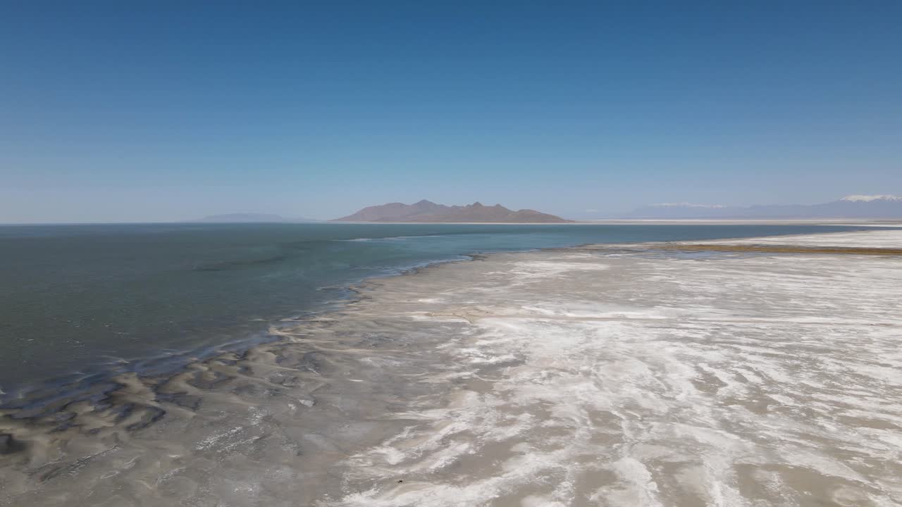 A 4K drone shot over the perfectly flat Bonneville Salt Flats, found west of the Great Salt Lake, in western Utah, with a shallow layer of standing water flooding the vast salt plain&rsquo;s surface