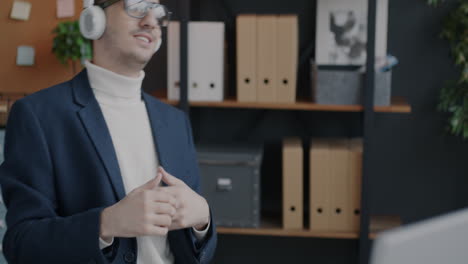 man dancing in office while listening to music with headphones