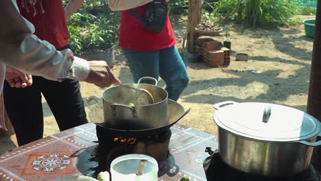 Toma-En-Cámara-Lenta-De-Revolver-Una-Olla-En-El-Fuego-En-Una-Clase-De-Cocina-Khmer-En-Camboya