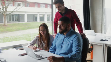 Grupo-De-Jóvenes-Gerentes-Creativos-Mirando-Una-Computadora-Portátil.