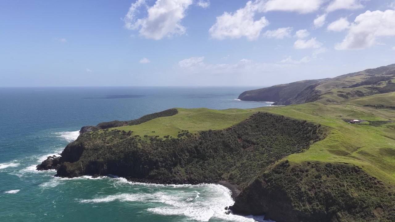 Vista aerea con drone di una costa frastagliata, scogliere costiere verdi e l'Oceano Pacifico sull'Isola del Nord della Nuova Zelanda.