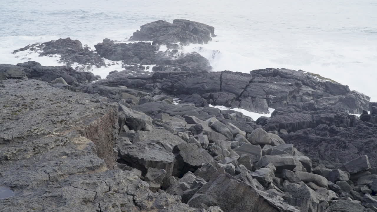 olas rompiendo en la costa negra y rocosa de islandia