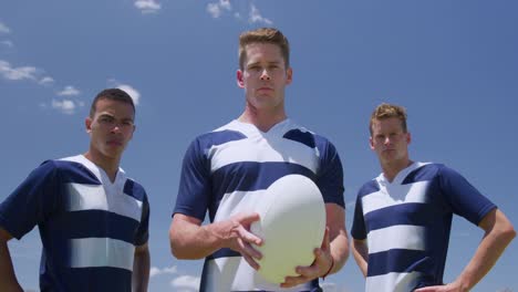 jugadores de rugby de pie con la pelota