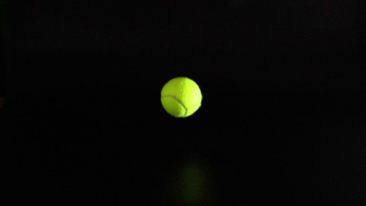 Tennispallo pomppii tummalla pinnalla