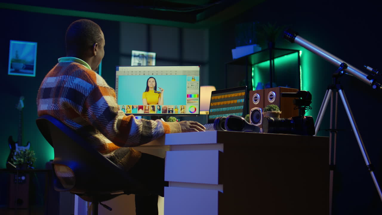 Man editing photos on his computer in a dark room