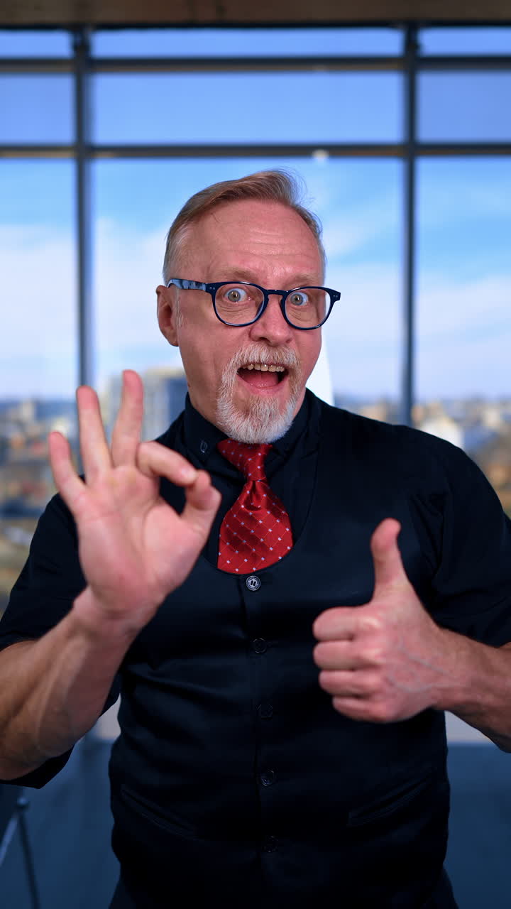 Energetic positive Caucasian male showing thumbs up to the camera. Portrait of a businessman showing approval gestures. Vertical video.