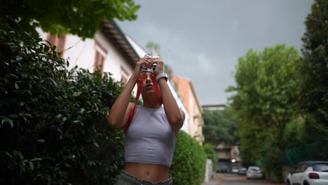 adolescente tomando una foto en la calle
