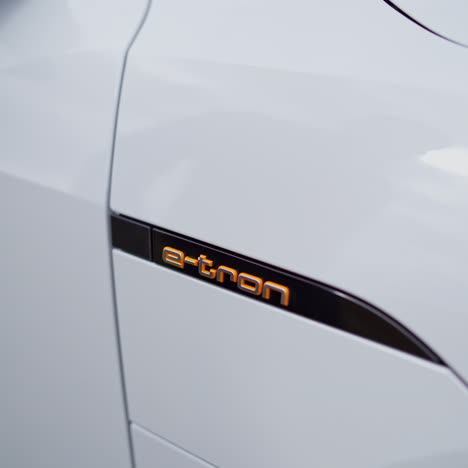 close-up detail of audi e-tron. male's hand plugging and unplugging the charger of an electric vehicle. automatic door opening and closing to reveal the charging hub.