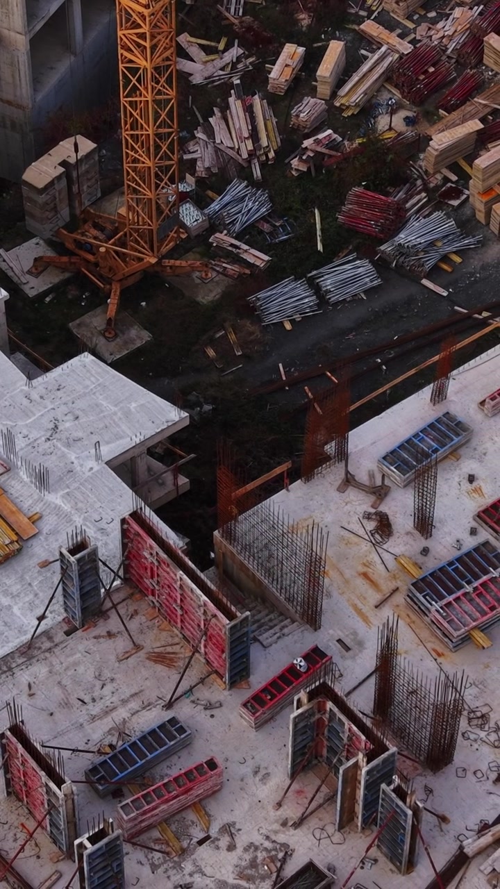 Construction site viewed from above with materials and equipment scattered