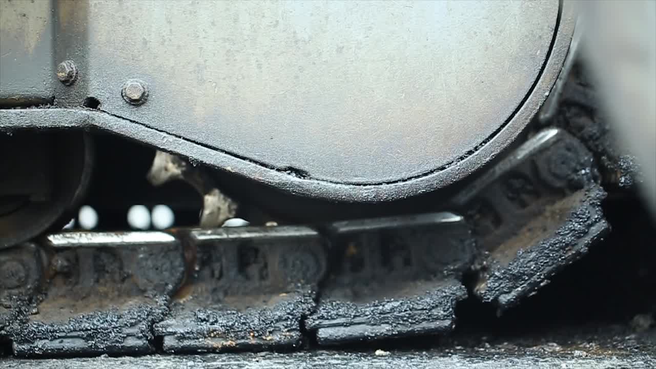 vista de cerca del proceso de construcción de carreteras de difusión, difusión o colocación de materiales de mezcla de asfalto utilizando una máquina de difusión de acabado de asfalto