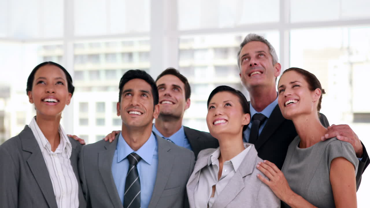 행복한 사업가들이 쳐다보고 있습니다.