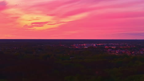 pink sunset over cityscape under dramatic sky, drone video