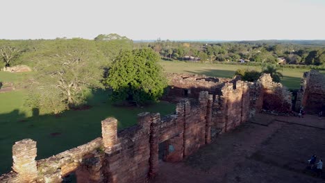 Aerial-orbit-around-sunlit-ruins-on-historic-south-american-building-wall,-san-ignacio-argentina