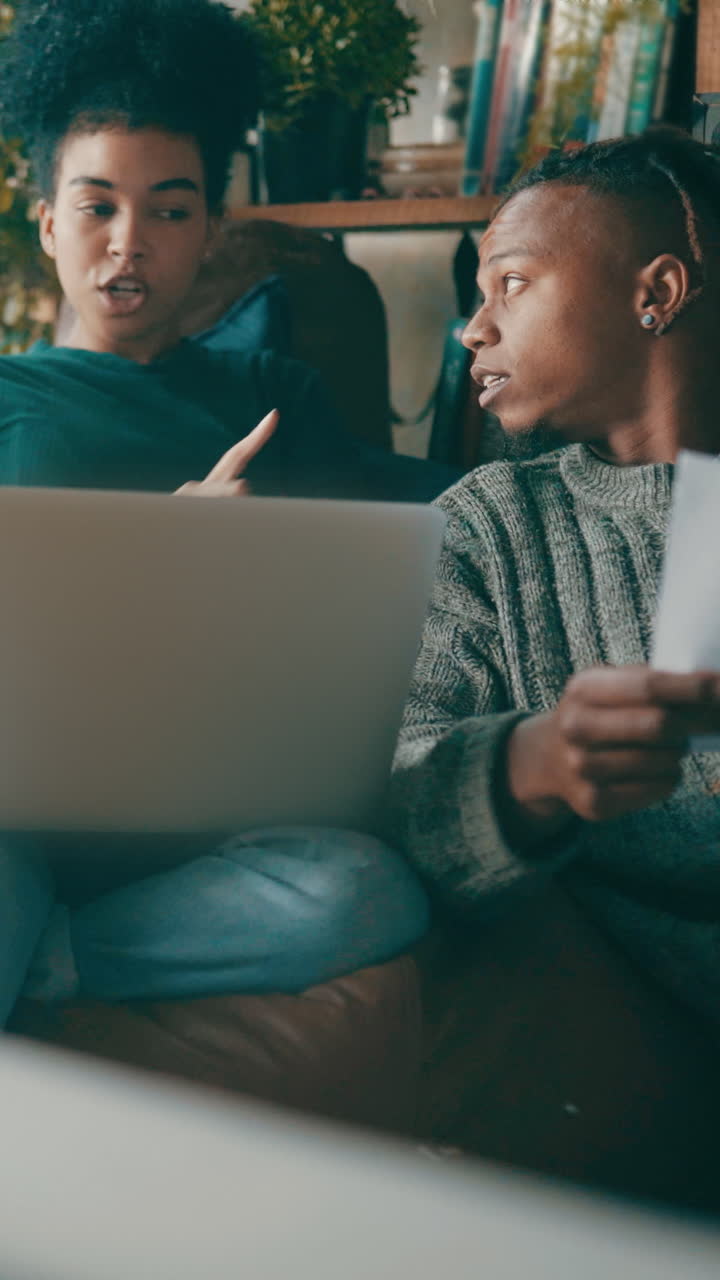 Young Couple Discussing Documents and Using Laptop at Home