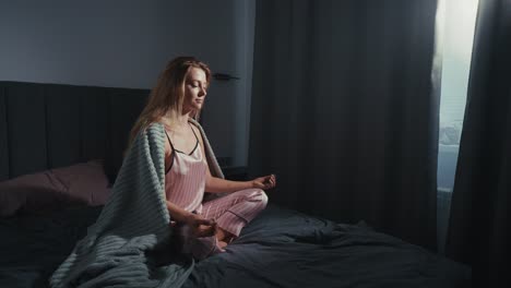 woman meditating in bed in the morning