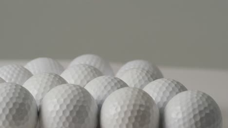 close up of golf balls on white background, copy space, slow motion