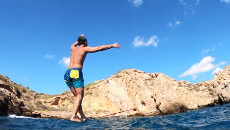 a sportsman keeps balance over a slack line