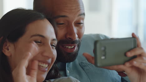 happy couple using smartphone video chat waving at baby smiling blowing kiss enjoying online communication relaxing at home