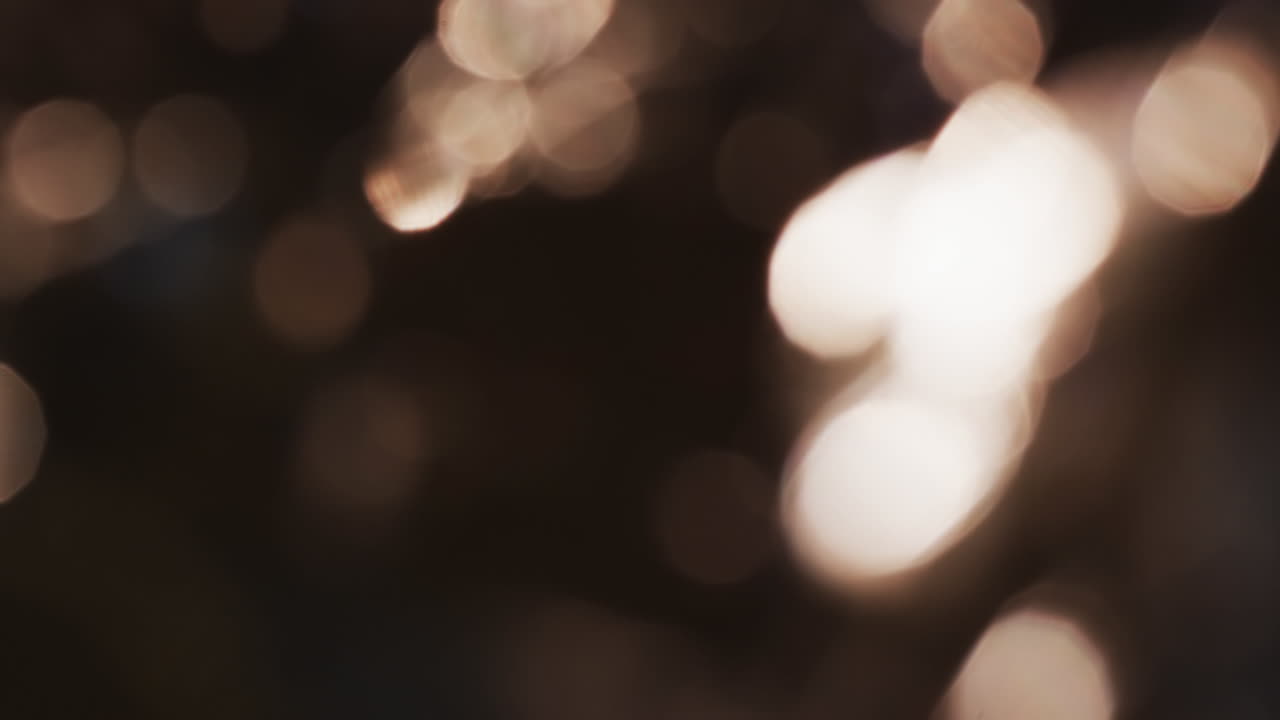 Video of flickering yellow bokeh spots of light with copy space