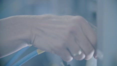 hand connecting a blue cable in a softly lit environment, close-up, panning shot