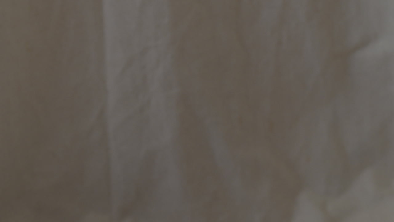 Tilt down from white sheet to old bible in Swedish with worn pages