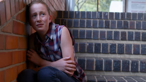 Sad-schoolgirl-sitting-alone-on-staircase