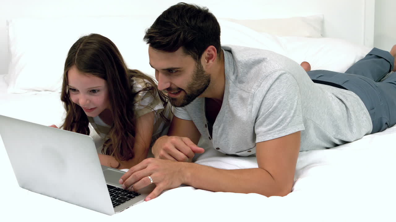padre e hija usando una computadora portátil