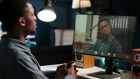 african american man enjoys video conferencing with manager at desk