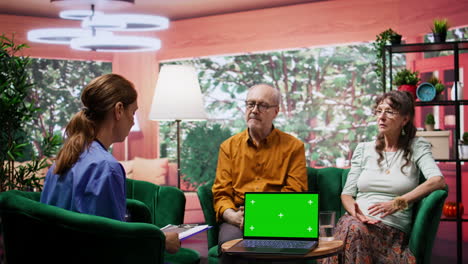 Pflegekraft-Krankenschwester-Berät-älteres-Paar-Neben-Chroma-Key-Mockup-Display