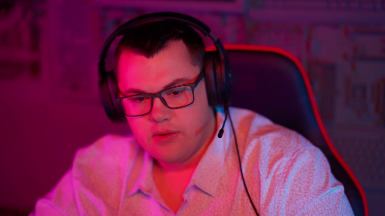 Giovane uomo concentrato con le cuffie che gioca sotto luci al neon