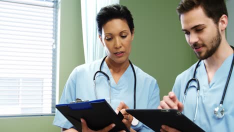 two doctors discussing over digital tablet